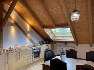 eine Küche mit einem Tisch und einer Decke mit einem Fenster in der Unterkunft Schleichhof Ammersee in Dießen am Ammersee
