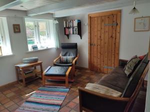 ein Wohnzimmer mit einer Couch und einem Sessel in der Unterkunft Ferienhaus Fischerkate in Sankt Peter-Ording