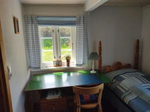 ein Schlafzimmer mit einem Schreibtisch und einem Bett und einem Fenster in der Unterkunft Ferienhaus Fischerkate in Sankt Peter-Ording