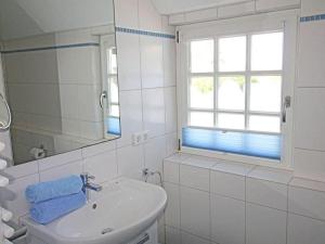 Baño blanco con lavabo y espejo en Haus Ruusenhoog - Apartment 5, en Rantum