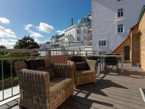 a patio with chairs and a table on a balcony at Peper Beach Street in Juist