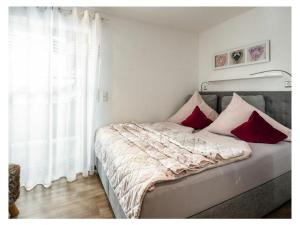 a bed with red and white pillows in a bedroom at Hochkalter - Reich family in Schönau am Königssee