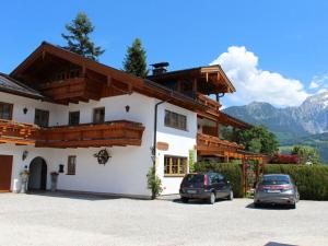 a building with two cars parked in a parking lot at Hochkalter - Reich family in Schönau am Königssee