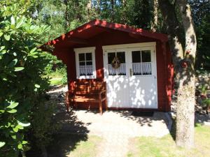 un cobertizo rojo y blanco con una silla en Elke Lüthje Modern retreat, en Hochdonn