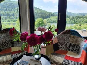 a vase of flowers on a table in front of a window at See & So Modern Retreat in Winterberg