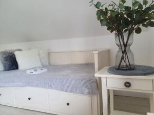 1 dormitorio con 1 cama y un jarrón con una planta en See & So Modern Retreat en Winterberg
