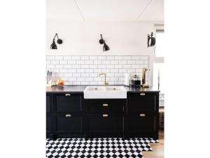 a black and white kitchen with a sink at Oceanhouse Modern Retreat in Den Oever