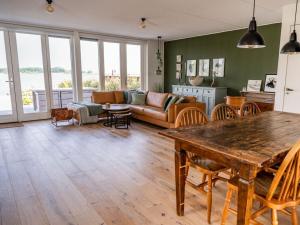 sala de estar con mesa y sofá en Oceanhouse Modern Retreat en Den Oever