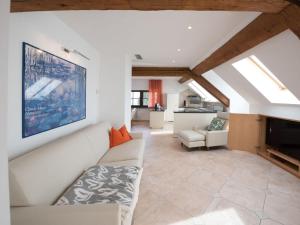 ein Wohnzimmer mit einem weißen Sofa und einem TV in der Unterkunft Landgoed Wendelstein in Appiano sulla Strada del Vino