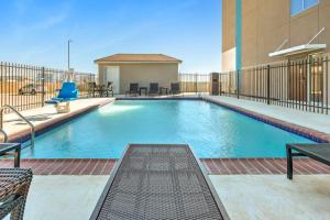 uma piscina num edifício com cadeiras e um edifício em Holiday Inn Express - San Antonio East I-10 , an IHG Hotel em San Antonio