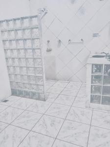 un bagno bianco con doccia e porta in vetro di Recanto Natural - Rock In Rio All Inclusive a Rio de Janeiro
