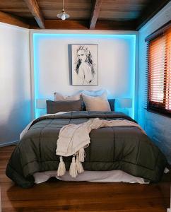 1 dormitorio con 1 cama grande en una habitación azul en Daylesford - FROG HOLLOW ESTATE - The Homestead, en Daylesford