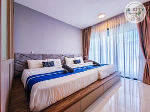a large bed in a room with a large window at Teega Suites by JBcity Home in Nusajaya