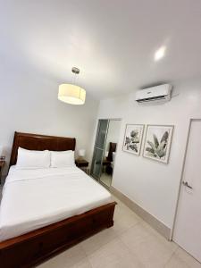 a bedroom with a bed and a air conditioner at HARMAN SUITES Moalboal in Moalboal