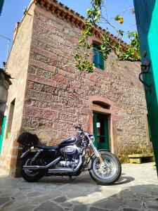 una motocicleta estacionada frente a un edificio de ladrillo en Andala agriturismo esperienziale en Samughèo