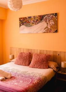 ein Schlafzimmer mit einem Bett und einem Gemälde an der Wand in der Unterkunft Zuhaitz Azpeitia entre Loyola y el mar in Azpeitia