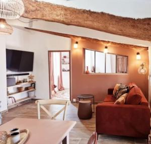 - un salon avec un canapé rouge et une table dans l'établissement Appartement avec terrasse en centre-ville, à LʼIsle-sur-la-Sorgue