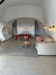 een slaapkamer met een bed, een bank en een tafel bij Logement troglodyte tout confort 42 min tgv Paris in Naveil