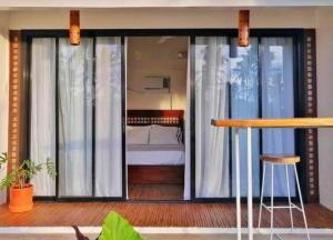 a room with a bed and a balcony at 11th Earth Farm and Resort in Nabua +20 photos