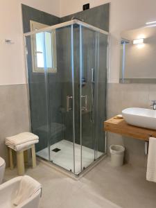 ミラノ・マリッティマにあるHotel Londraのバスルーム(ガラス張りのシャワー、シンク付)