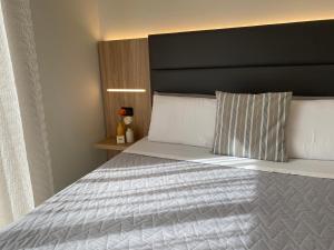 een slaapkamer met een groot bed met een zwart hoofdeinde bij Hotel Londra in Milano Marittima