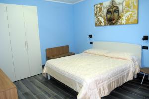 um quarto com uma cama e um quadro na parede em Appartamento Badiella em Trapani