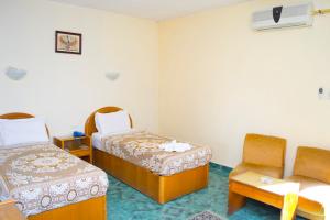 um quarto com duas camas e uma cadeira em Semiramis hotel em Alexandria