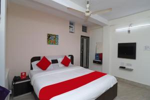 1 dormitorio con 1 cama grande con almohadas rojas en Hotel Padoshi Puri Near Sea Beach & Temple - Parking Facilities - Best Hotel in Puri en Puri