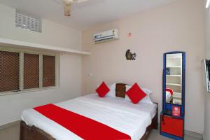 a bedroom with a bed with red pillows on it at Hotel Padoshi Puri Near Sea Beach & Temple - Parking Facilities - Best Hotel in Puri in Puri