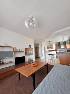sala de estar con mesa y cocina en Giedre Apartments - Taikos, en Kaunas