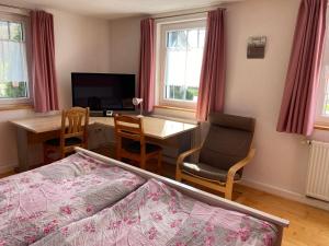a bedroom with a bed and a desk and a table at Ferienzimmer Oelhaf Zimmer in Rosé Self Check-In mit Key-Tresore in Wilhelmsdorf