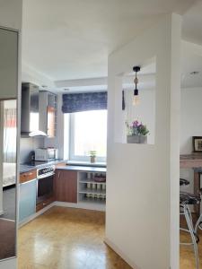 a kitchen with white walls and a large window at Giedre Apartments - Taikos in Kaunas