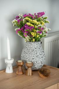 un vaso pieno di fiori sopra un tavolo di eugea apartments a Città di Lefkada Altre 67 foto