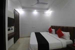 Un dormitorio con una cama con almohadas rojas. en Hotel Golden Prime, en Nueva Delhi