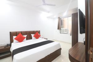 1 dormitorio con 1 cama grande con almohadas rojas en Hotel Golden Prime, en Nueva Delhi