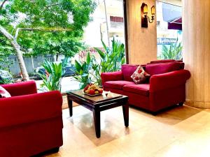 a living room with two red couches and a coffee table at Caesar's Park Hotel in Beirut