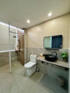 a bathroom with a toilet and a sink and a shower at Florencia's Inn in Panglao