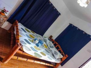a bed with a pillow and a blue curtain at Don Leo's BnB in Esperanza +8 photos