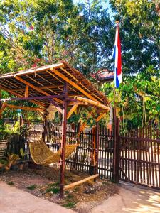 a wooden gazebo with a flag and two chairs at Don Leo's BnB in Esperanza