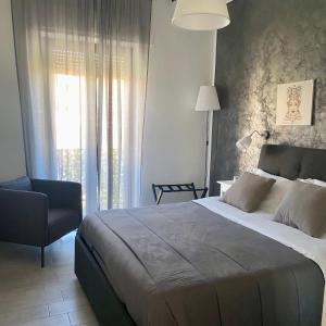 a bedroom with a bed and a chair and a window at I SARACENI in Syracuse