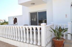 a white fence on a house with a potted plant at Villa Lankas with Heated pool in Ayia Napa