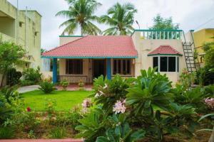 ein Haus mit einem roten Dach und einem Hof in der Unterkunft BRUNDHA HOMESTAY Villa with Garden in Tirupati