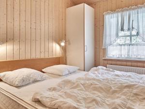 En eller flere senge i et værelse på Holiday home Nexø IX