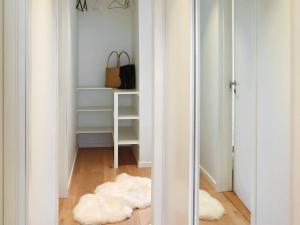 a room with a hallway with white walls and a mirror at 6 person holiday home in Søndeled in Søndeled