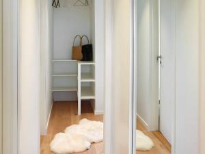 a room with a hallway with white walls and a mirror at Holiday home Søndeled II in Søndeled