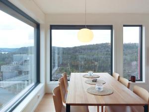 a dining room with a table and a large window at Holiday home Søndeled II in Søndeled