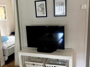 TV de pantalla plana sentada en una mesa en una habitación en Holiday home ODENSBACKEN IV en Stora Mellösa