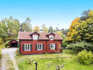 una casa roja en medio de un campo en Holiday home EKERÖ, en Ekerö