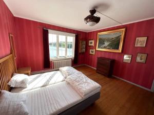 - une chambre aux murs rouges avec un lit et une fenêtre dans l'établissement Holiday home FREDRIKSBERG III, à Fredriksberg