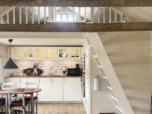 uma cozinha no sótão com armários brancos e uma escada em Holiday home VÄXJÖ II em Växjö